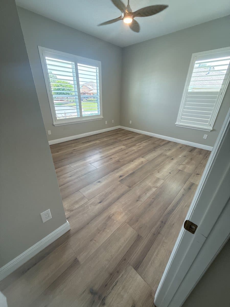 Wide-plank luxury vinyl flooring installed in a bedroom by Black Gold Flooring